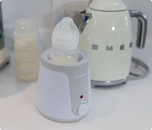 Snookums baby bottle warmer with a baby bottle warming on a kitchen counter