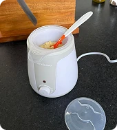 Snookums bottle and food warmer heating baby food with spoon